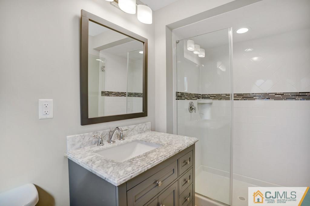 17 Greenbrook Road Middlesex, NJ 08846 - Photo 5 of 24 a bathroom with a granite countertop sink a mirror and a shower