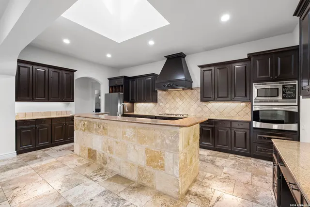 a kitchen with stainless steel appliances granite countertop a sink stove and cabinets