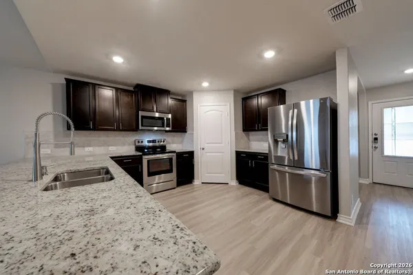 a kitchen with granite countertop stainless steel appliances and wooden cabinets