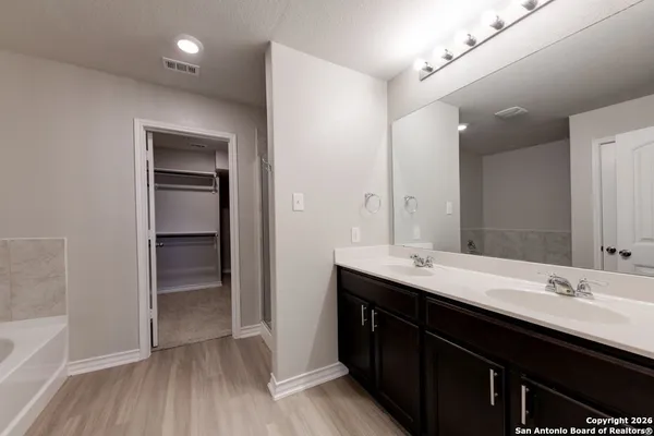 a bathroom with a double vanity sink a mirror and a bathtub