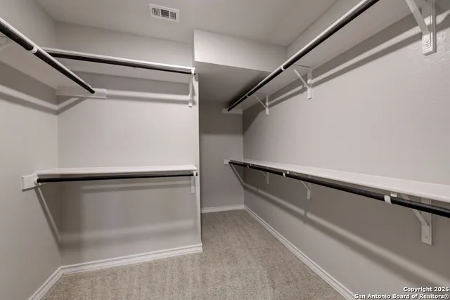 a view of walk in closet with empty racks