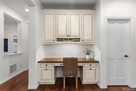a kitchen with stainless steel appliances granite countertop white cabinets and chairs