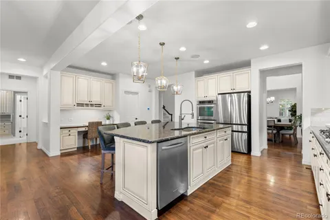 a kitchen with stainless steel appliances granite countertop a sink stove and refrigerator