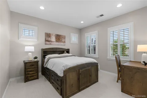 a bedroom with a bed and a table in it with window