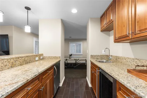 a kitchen with granite countertop kitchen island a sink stove and cabinets