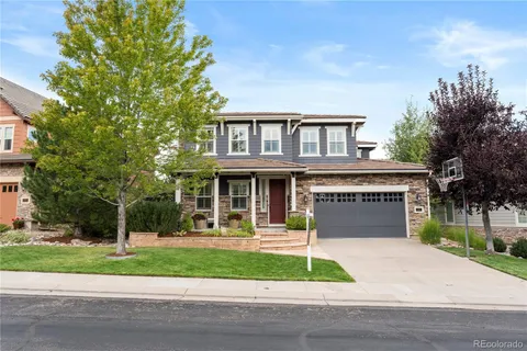a front view of a house with a yard and potted plants
