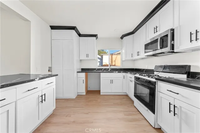 a kitchen with stainless steel appliances granite countertop a stove and a sink