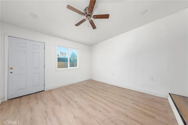 an empty room with a window and a ceiling fan