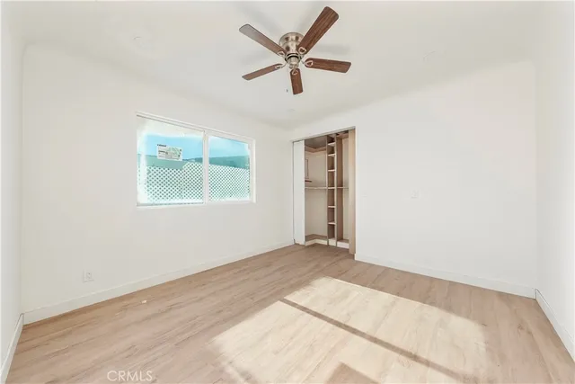 an empty room with fan and windows