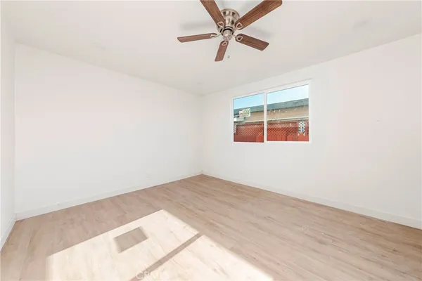 an empty room with a window and a fan