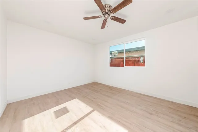 an empty room with a window and a fan