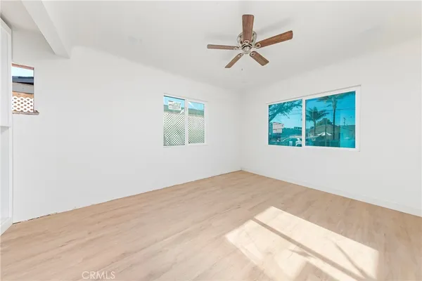 a view of a big room with windows and ceiling fan
