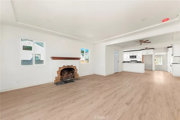 a view of empty room with a fireplace and wooden floor