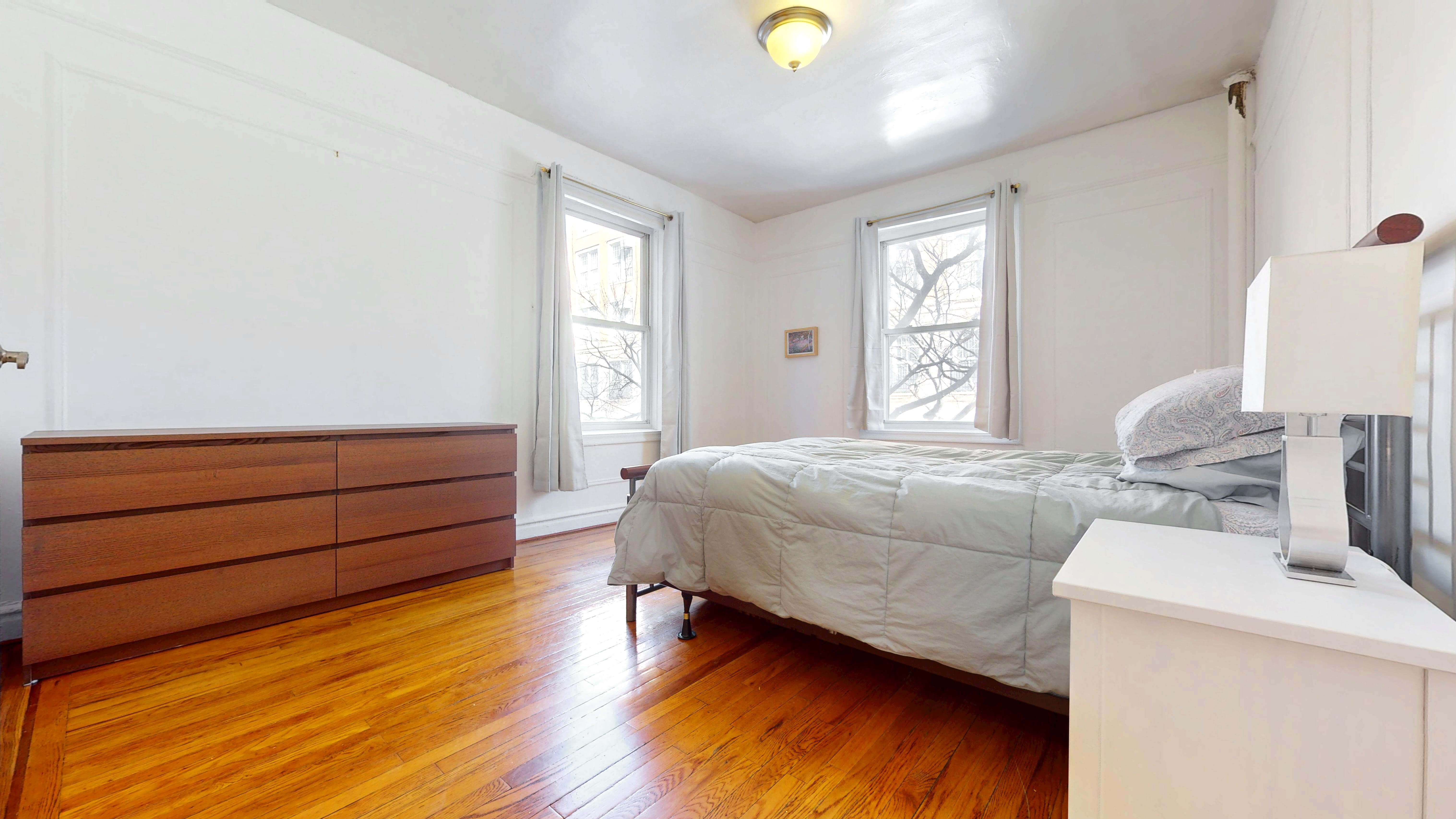 2081 Cruger Avenue, Unit 2K Bronx, NY 10462 - Photo 10 of 12 a bedroom with a bed and wooden floor