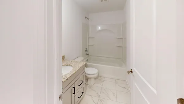a bathroom with a granite countertop toilet a sink and a mirror