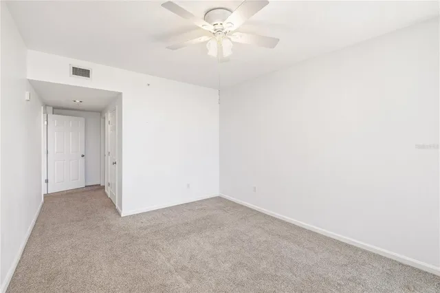 an empty room with a ceiling fan and a fan
