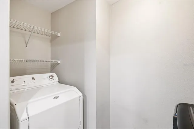 a view of washer and dryer with bathroom in the background