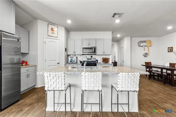 a view of kitchen with refrigerator and wooden floor
