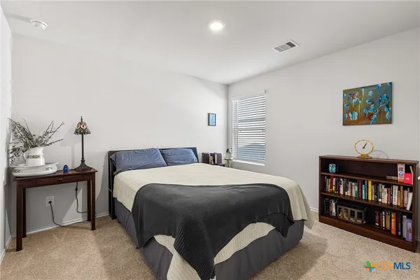 a bedroom with a bed and a book shelf