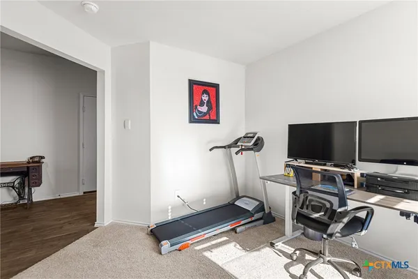 a view of a workspace with furniture and a flat screen tv