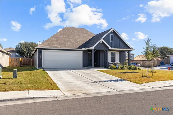 a view of yellow house with swimming pool and a yard