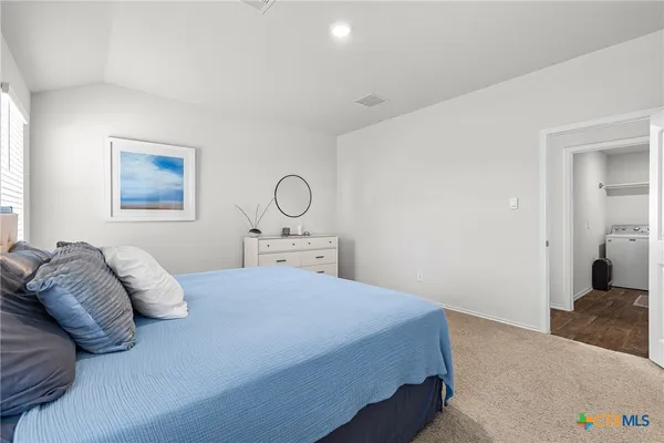 a bedroom with a large bed and a chandelier