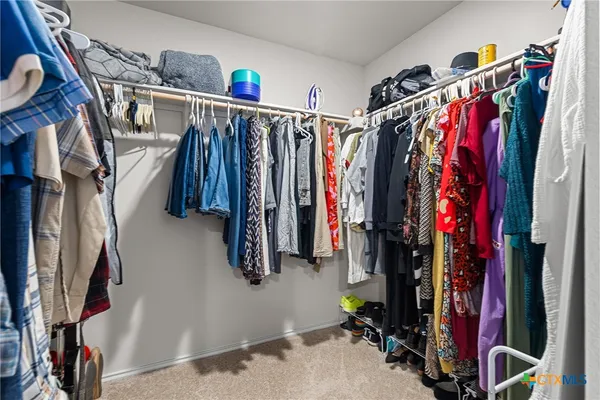 a view of walk in closet with clothes