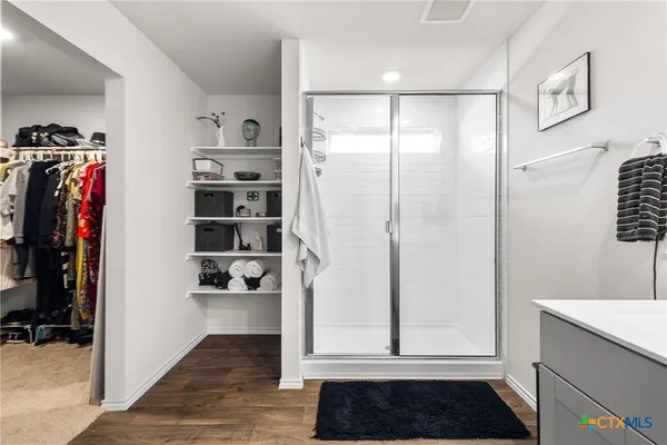 a view of walk in closet with clothes and shoes