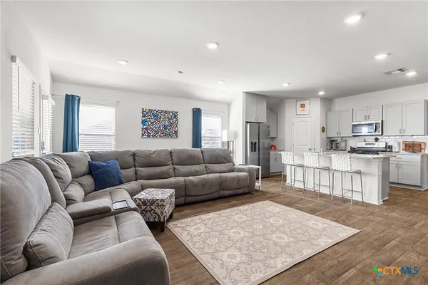 a living room with furniture and kitchen view