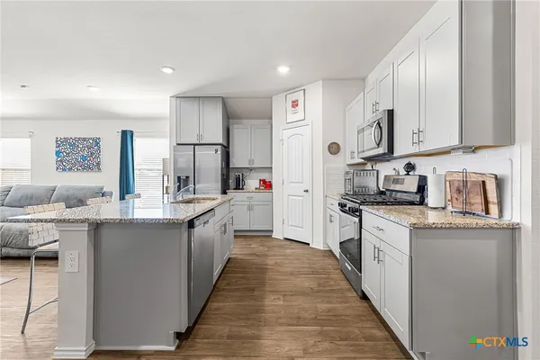 a kitchen with stainless steel appliances granite countertop lots of counter top space a sink and cabinets