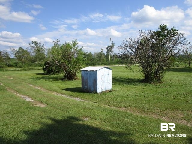 20705 Greek Cemetery Road Robertsdale, AL 36567 - Photo 22 of 25 View of green lawn featuring a shed