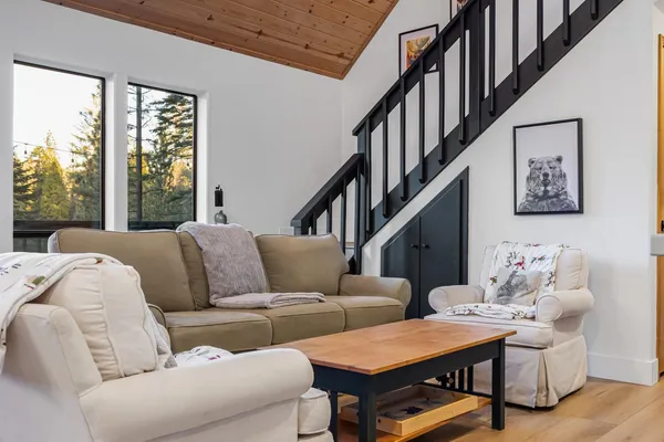 a living room with furniture stairs and a flat screen tv