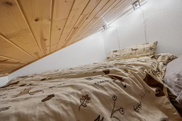 a bedroom with a bed and wooden floor