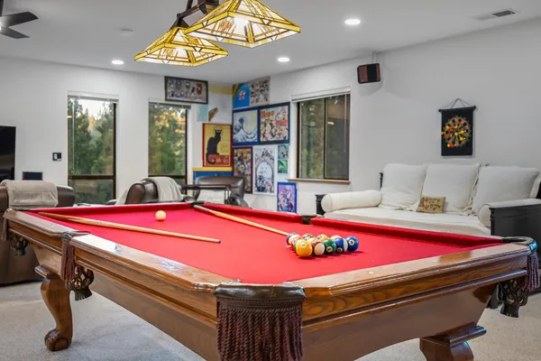 a room with pool table and windows