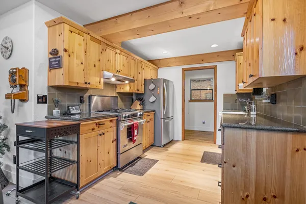 a kitchen with stainless steel appliances granite countertop a sink refrigerator and cabinets