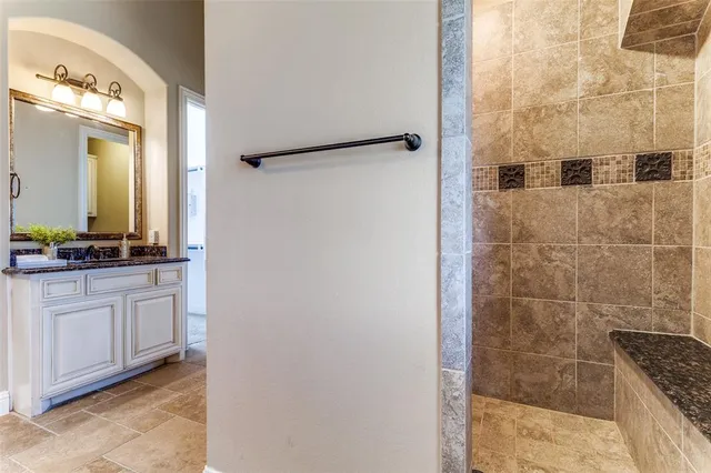 a bathroom with a granite countertop shower a mirror and a sink