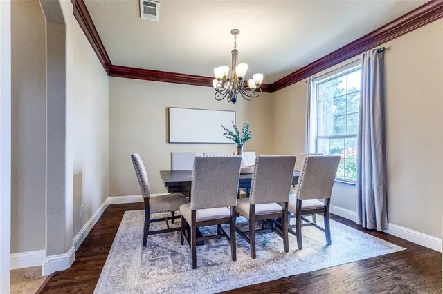 a view of a dining room with furniture a chandelier and wooden floor