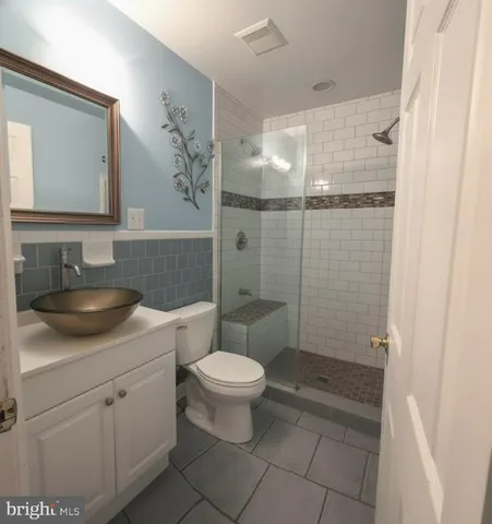 a view of a livingroom with a chandelier fan and wooden floor