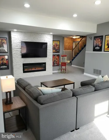a living room with furniture a fireplace and a kitchen view