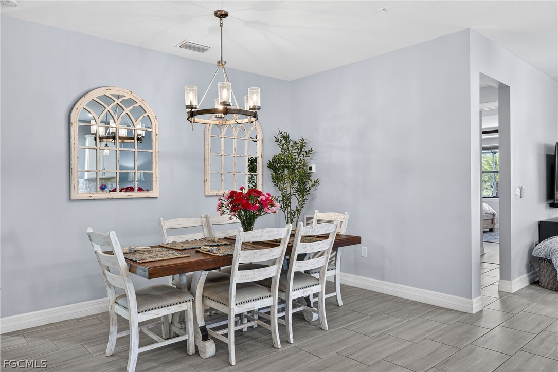 11914 Bourke Place Fort Myers, FL 33913 - Photo 11 of 49 a dining room with furniture a chandelier and wooden floor