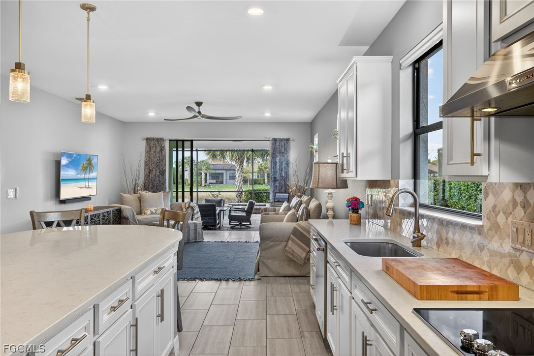11914 Bourke Place Fort Myers, FL 33913 - Photo 5 of 49 a large kitchen with kitchen island a large counter top space a sink stainless steel appliances and cabinets