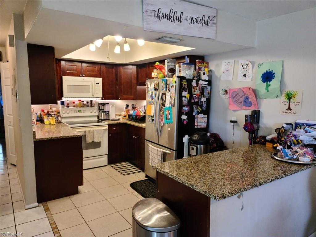 5563 17th Avenue Southwest Naples, FL 34116 - Photo 25 of 28 a kitchen with a sink a stove and cabinets