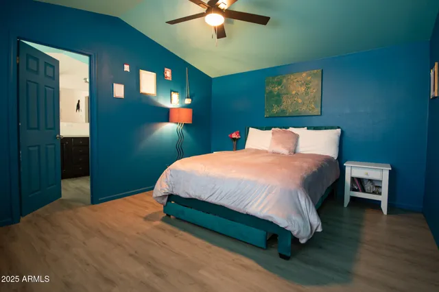 a bedroom with a bed wall painting and a chandelier