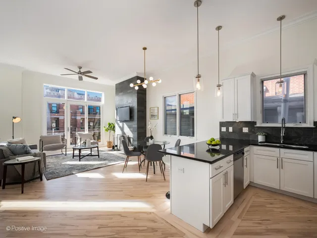 a kitchen with counter top space appliances and a view of living room