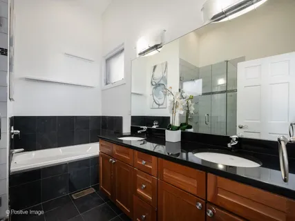 a bathroom with a sink a bathtub a mirror and a shower