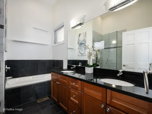 a bathroom with a sink a bathtub a mirror and a shower