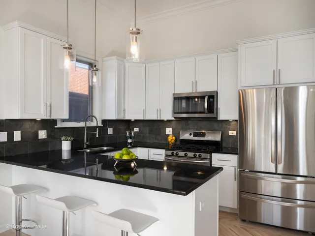a kitchen with a sink stainless steel appliances and white cabinets