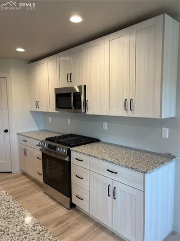 a kitchen with granite countertop a stove and a sink