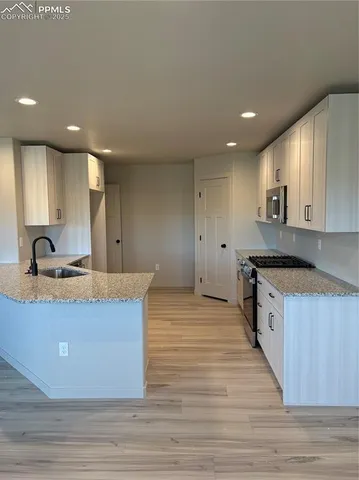 a large kitchen with stainless steel appliances granite countertop a sink and a stove