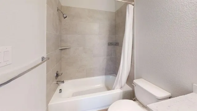 a white bath tub sitting next to a white toilet